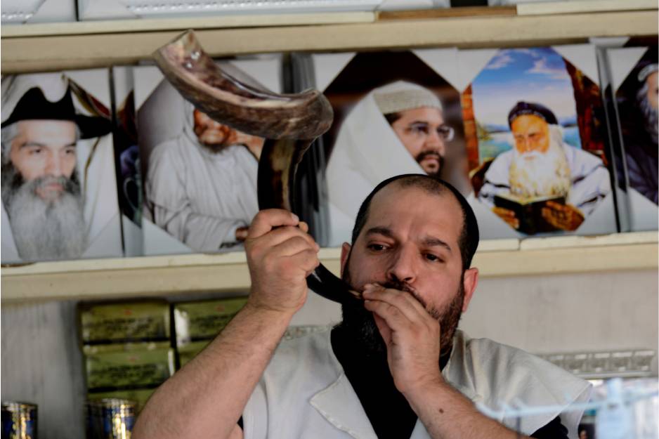 A man blows the shofar at the Rambam’s Tomb souvenir shop