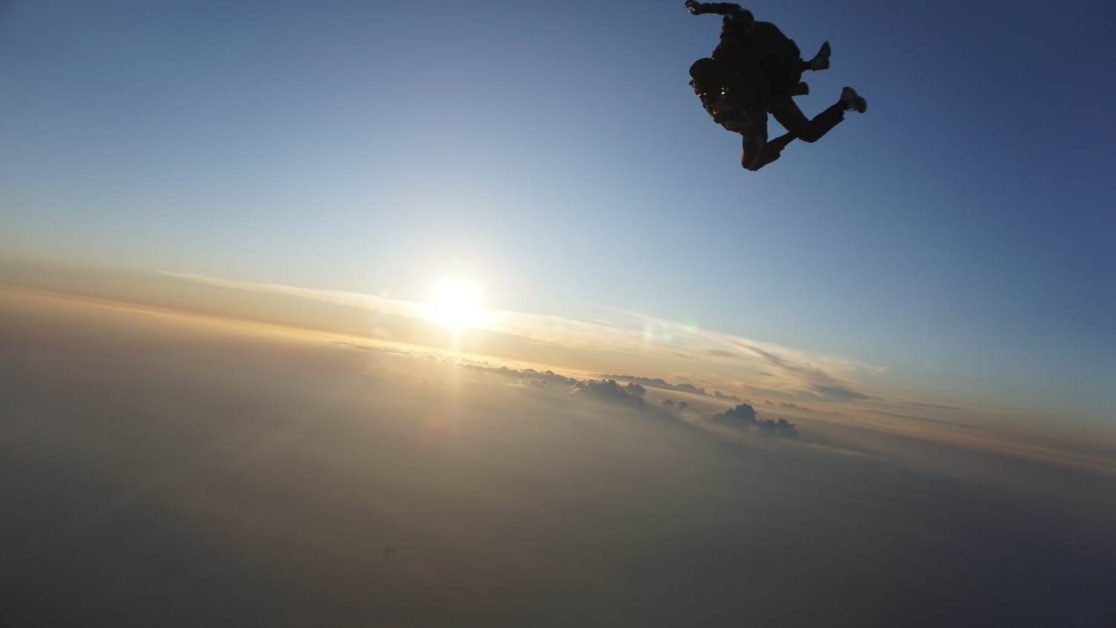 Paradive sky diving while in the air viewing sundown