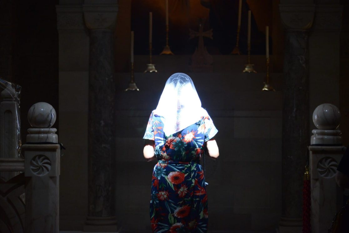 Woman is praying at Jerusalem Church of the Holy Sepulchre